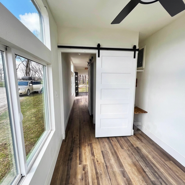 Cabin interior with barn door and hardwood floors